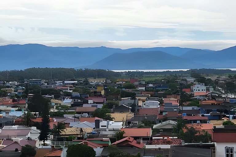 Aconchego, praia e vista panorâmica das montanhas.